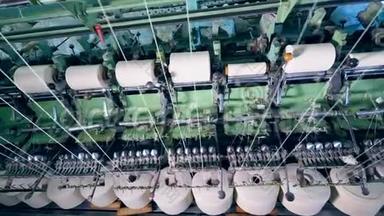 在一家纺织厂，白线在现代机器上旋转。